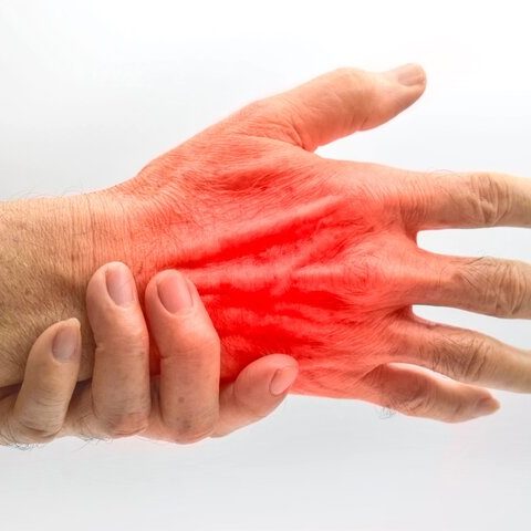 wrist and hand pain A hand gripping another hand, with a red glow indicating discomfort or pain.