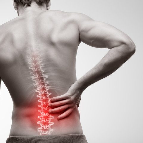 Person holding lower back in pain, with a highlighted area indicating discomfort.