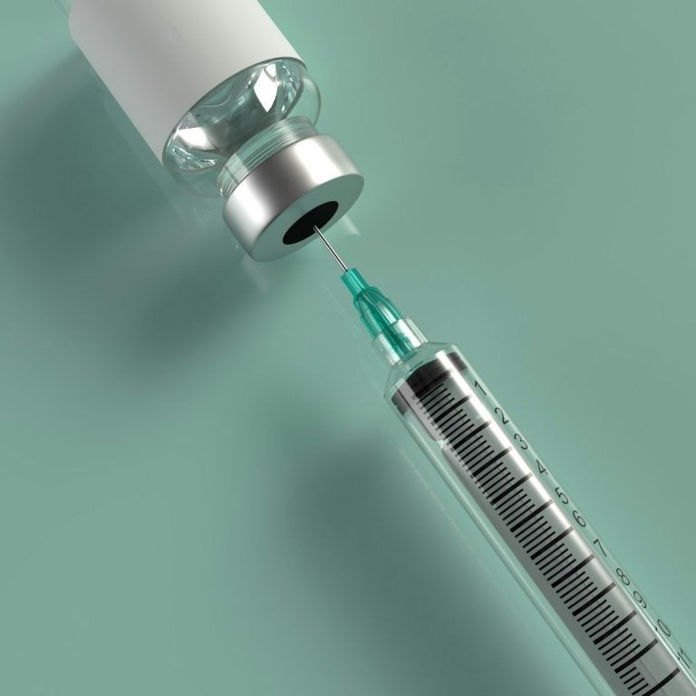 Container of steroid injection with a syringe beside it.